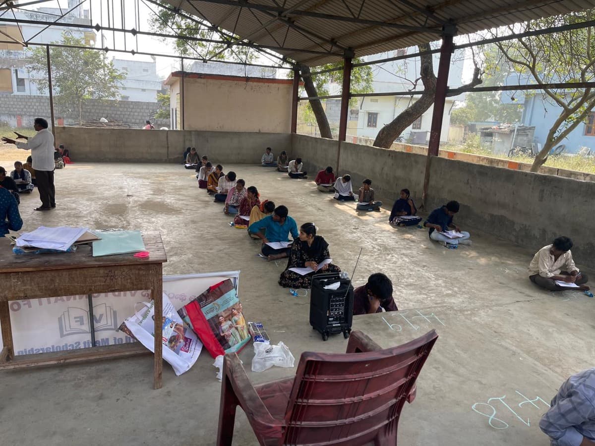 Students writing screening test in outdoor area